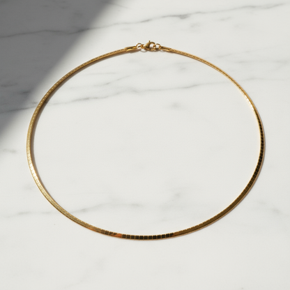 Gold omega chain on marble