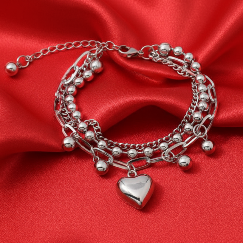 Heart charm bracelet on bright red satin background